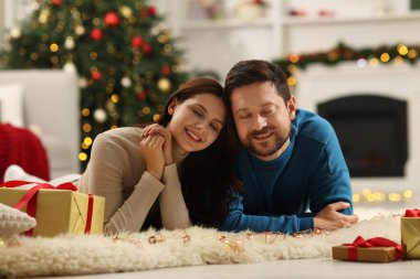 Mutlu çift Noel için dekore edilmiş odada birlikte vakit geçiriyor.
