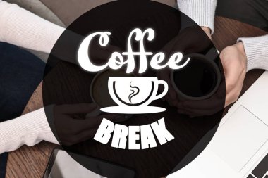 Meslektaşlar kafedeki ahşap masada kahve molası veriyorlar.