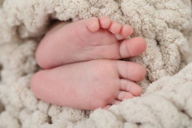 Yumuşak battaniyeye sarılı yeni doğmuş bebek, yakın plan.