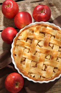 Lezzetli ev yapımı elmalı turta ve elmalar ahşap masada, düz yatıyordu.