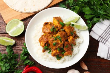 Tavuklu tikka masala. Pirinç, ahşap masada servis edilir.