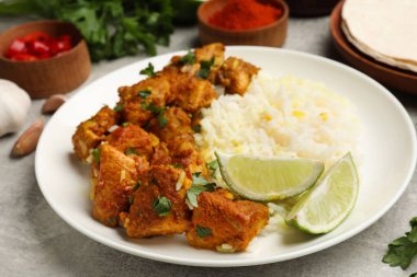 Pirinç, maydanoz ve limonlu leziz tavuk tikka masala. Gri desenli masa, yakın plan.
