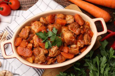 Yemek tabağında ve malzemelerde nefis pişirilmiş güveç.