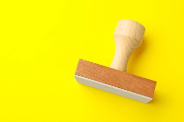 Sarı arka planda bir tahta damga, üst manzara. Metin için boşluk