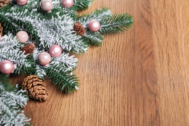 Ahşap arka planda koni ve süslemeleri olan güzel Noel ağacı dalları, yakın plan. Metin için boşluk