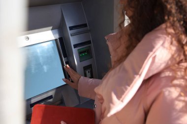 Cüzdanı olan bir kadın modern para makinesi kullanıyor, yakın plan. ATM