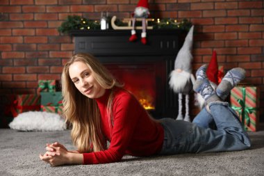 Noel atmosferi. Evde şöminenin yanında güzel bir kadın var.
