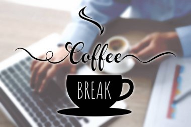 Kahve molası. Bir fincan sıcak içeceği olan kadın masadaki bilgisayarı kullanıyor, yakın plan.