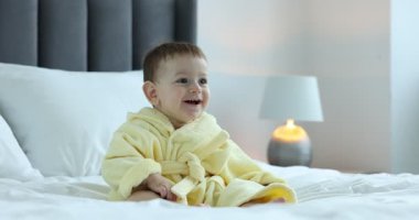 Evde bornozlu şirin bir bebek var.