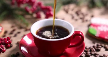 Bardağa, fasulyeye ve Noel dekoruna aromatik kahve dök.