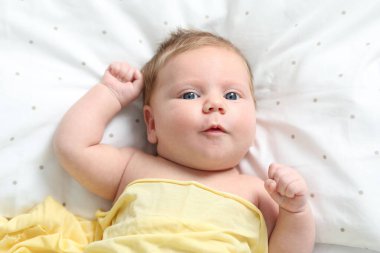 Yeni doğmuş şirin bir bebek. Evde yatakta, üst tarafta.