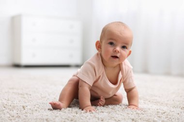 Evde yerde yatan şirin bir bebeğin portresi.