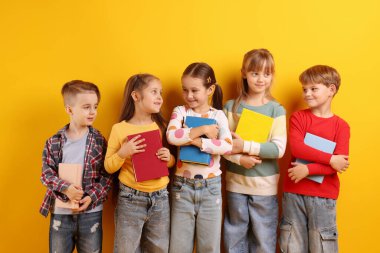 Turuncu arka plan kitapları olan sevimli çocuklar.