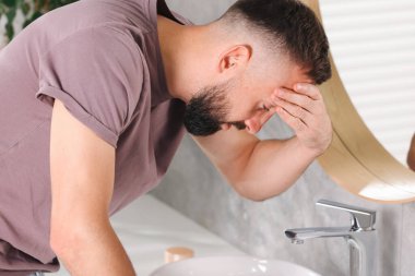 Banyo lavabosundan muzdarip bir adam.