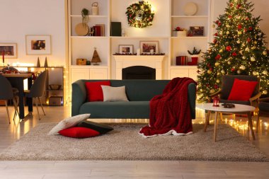 Noel ağacı, kanepe, şömine ve şenlikli dekorlu şık bir oda. İç tasarım