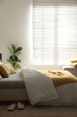 Yatak odasının penceresinin yanında çarşafları olan büyük bir yatak. Metin için boşluk