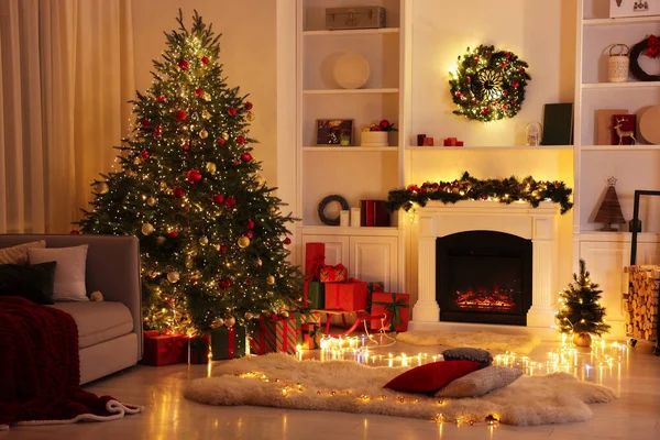 Noel ağacı, şömine ve şenlikli dekorlu şık bir oda. İç tasarım