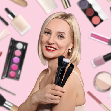 Düşen dekoratif kozmetik ürünlerine karşı pembe arka planda fırçaları olan güzel bir makyaj sanatçısı.
