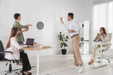 Bir grup meslektaşım ofiste dart oynuyor.