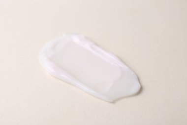 Bej arka planda nemlendirici krem örneği, yakın plan.