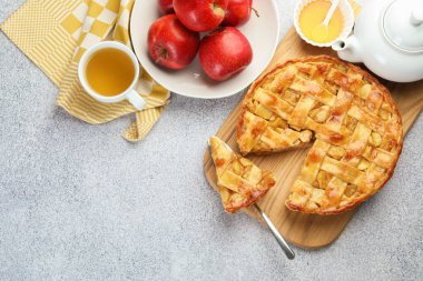 Lezzetli ev yapımı turta, elmalar ve çay gri desenli masa, düz yatak. Metin için boşluk