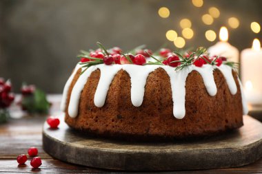 Üzerinde krema, kızılcık ve biberiye olan nefis bir Noel pastası. Gri arka planda, bulanık ışıklı, yakın plan. Bokeh etkisi