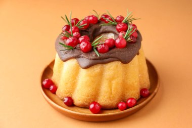 Soluk turuncu arka planda kızılcıklı lezzetli bir Noel pastası. Yakın plan.