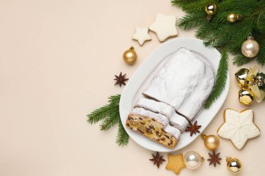 Geleneksel Stollen pastası, kurabiyeler ve Noel dekorunu beyaz masaya koyun. Metin için boşluk