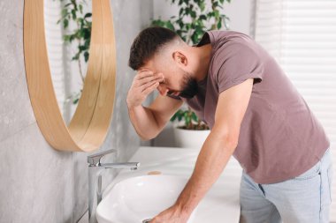 Banyo lavabosundan muzdarip bir adam.