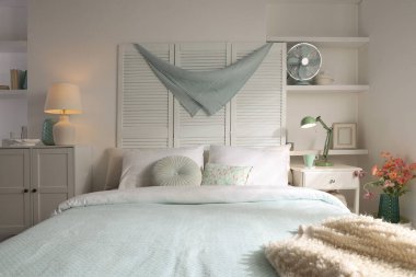 Büyük yataklı, yastıklı ve lambalı şık bir yatak odası. İç tasarım