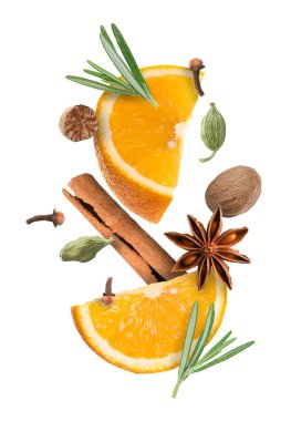 Sıcak şarap malzemeleri: beyaz zemine düşen portakal dilimleri ve baharatlar. Geleneksel Noel içkisi