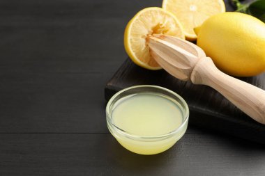 Taze limon suyu, meyveler ve siyah ahşap masada sıkma, yakın plan. Metin için boşluk