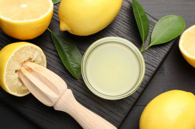 Taze limon suyu, meyveler ve sıkma siyah ahşap masa, düz uzanma