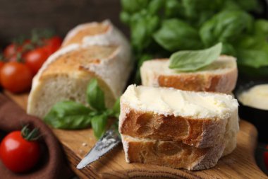 Tereyağlı, fesleğenli, domatesli ve bıçaklı ekmek dilimleri.