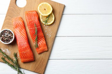 Somon fileto parçaları, baharatlar ve limon beyaz ahşap masa, üst manzara. Metin için boşluk