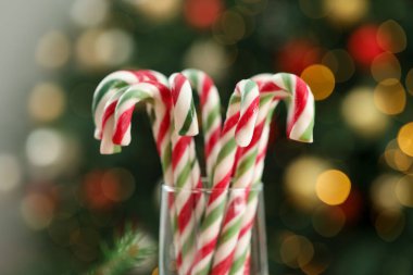 Bulanık ışıklara karşı cam çubuk şekerler, yakın çekim ve bokeh etkisi. Noel hediyesi