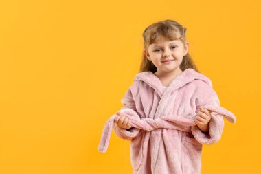 Sarı arka planda bornozlu tatlı kız. Metin için boşluk