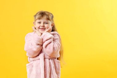 Sarı arka planda bornozlu mutlu kız. Metin için boşluk