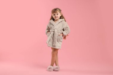 Pembe arka planda bornozlu tatlı bir kız.