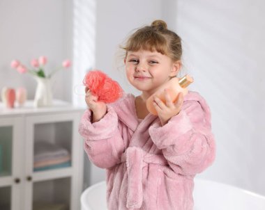 Banyo gereksinimleri olan bornozlu mutlu bir kız.