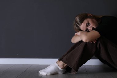 Siyah duvarın yanında depresif bir genç kız.