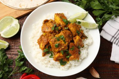 Tavuklu tikka masala. Pirinç, ahşap masada servis edilir.