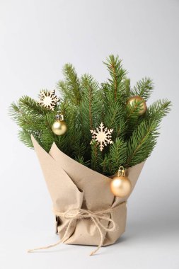 Gri arka planda kağıda sarılı güzel Noel ağacı dalları