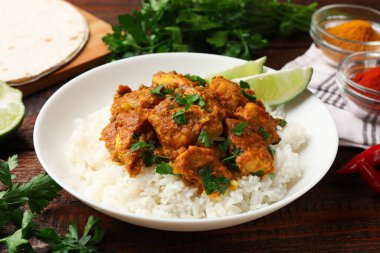 Pirinçli tavuk tikka masala, ahşap masada servis edilir, yakın plan.