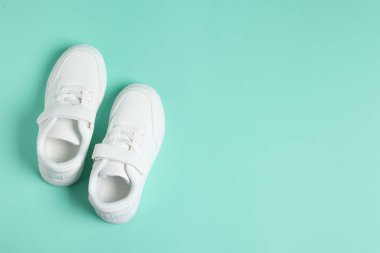 Turkuaz arka planda bir çift çocuk spor ayakkabısı, mesaj için en üstten görüş. Şık ayakkabılar.