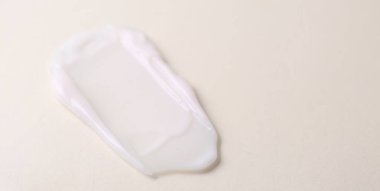 Bej arka planda nemlendirici krem örneği, yakın plan. Metin için boşluk