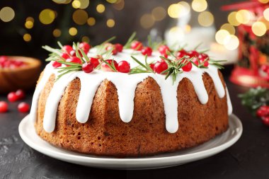 Bulanık ışıklara karşı kremalı, kızılcıklı ve biberiyeli lezzetli bir Noel pastası.