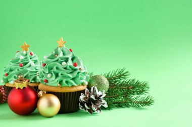 Noel ağacı şeklinde kekler ve yeşil arka planda şenlikli dekorlar, yakın plan. Metin için boşluk