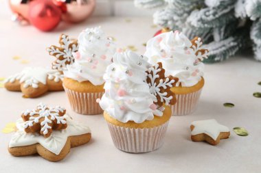 Noel dekorlu lezzetli kekler ve beyaz masada zencefilli kurabiyeler, yakın plan.