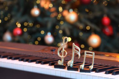 Piyano ve Noel ağacı üzerine altın notalar, yazı için yer. Bokeh etkisi